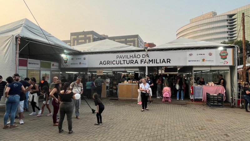 Imagem mostra visitantes no pórtico de entrada do Pavilhão da Agricultura Familiar no Acampamento Farroupilha