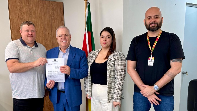 Secretário Covatti segura processo da Consulta Popular com o prefeito de Sede Nova ao seu lado direito e dois servidores da SDR no seu lado esquerdo.