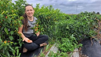 Mulher mostra produção em canteiro